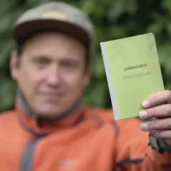 Mann hält grünen Jagdschein in die Kamera. Nach 5 Jahren ist er wieder im Besitz des Dokuments.