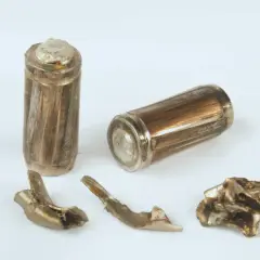 Zwei beschädigte Batterien und Fragmente, die die Teilmantelgeschoss Wirkung zeigen.