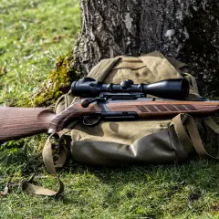 Jagdrepetierer Merkel Helix mit Zielfernrohr, auf Rucksack im Gras liegend.