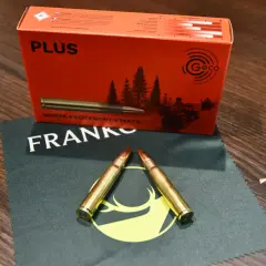 Zwei Patronen im Kaliber 8x57IS liegen auf einem Tuch. Die Verpackung im Hintergrund verspricht eine gute Reichweite.