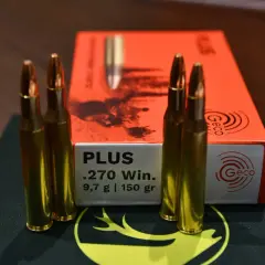 Vier Patronen .270 Win. von Geco liegen neben der orangefarbenen Packung. Ideal für die Jagd auf Schwarzwild.