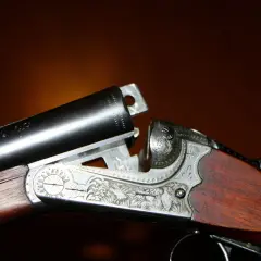 Detailaufnahme einer verzierten Flinte mit Stahlschrotbeschuss. Das Holzschaft und die Gravuren sind gut sichtbar.
