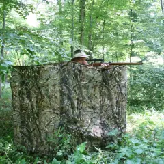 Jäger im Tarnzelt im Wald, bereit, richtig blatten.
