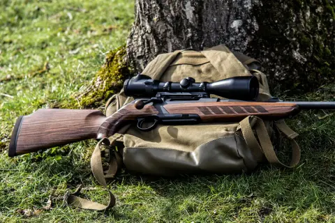 Jagdrepetierer Merkel Helix mit Zielfernrohr, auf Rucksack im Gras liegend.