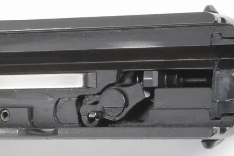 Detailaufnahme des Mechanismus einer Pistole, der die Sicherung zeigt.