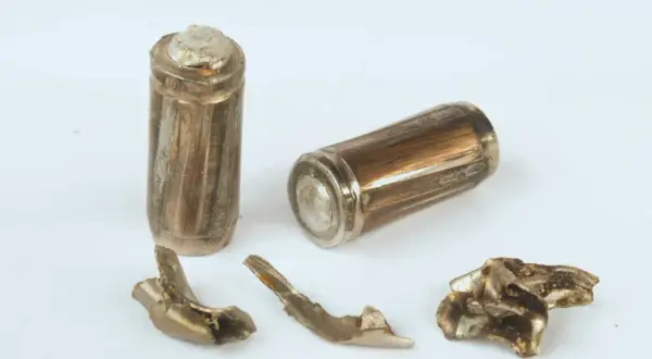 Zwei beschädigte Batterien und Fragmente, die die Teilmantelgeschoss Wirkung zeigen.