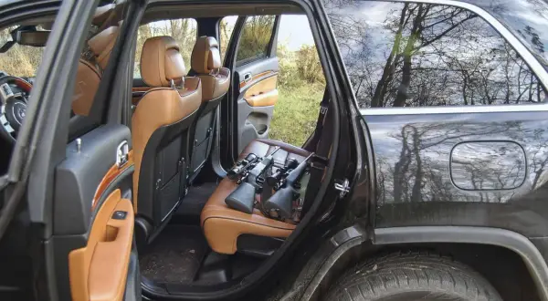 Zwei Gewehre mit Zielfernrohren liegen auf den Ledersitzen für den waffentransport im auto.