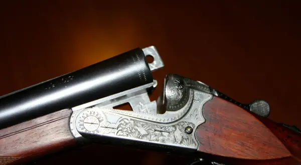 Detailaufnahme einer verzierten Flinte mit Stahlschrotbeschuss. Das Holzschaft und die Gravuren sind gut sichtbar.