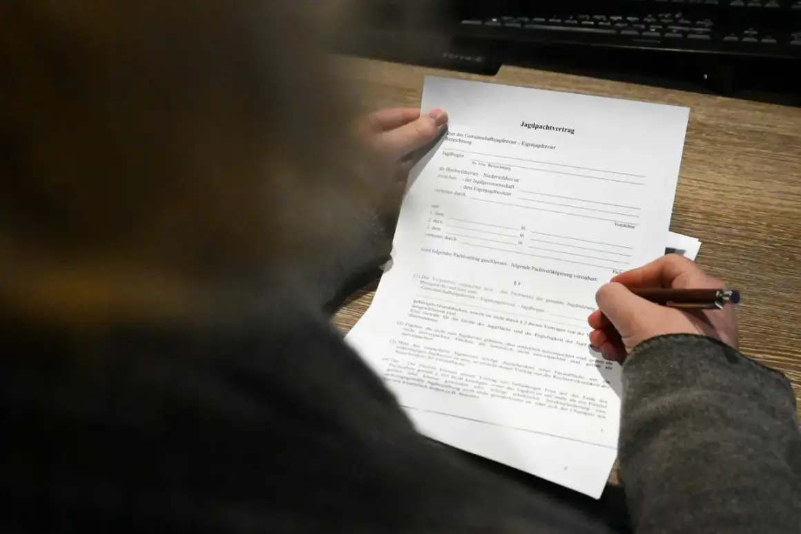 Ein Jagdpachtvertrag wird von einer Hand gehalten, die einen Stift führt. Der Text erwähnt den entgeltlichen begehungsschein.