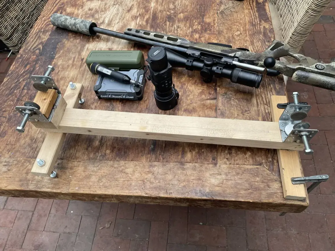 Selbstgebaute Gewehrauflage aus Holz und Metallteilen, daneben ein Jagdgewehr mit Schalldämpfer, Zielfernrohr und Wärmebildgerät.