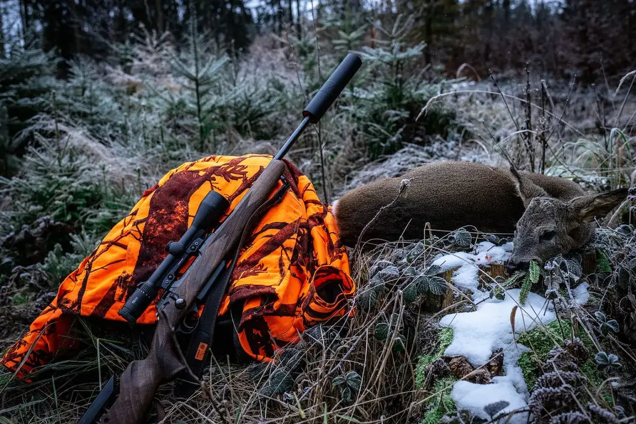 Gewehr mit Schalldämpfer und Tarnjacke neben erlegtem Reh. Die 6.5 Creedmoor eignet sich gut für solches Wild.