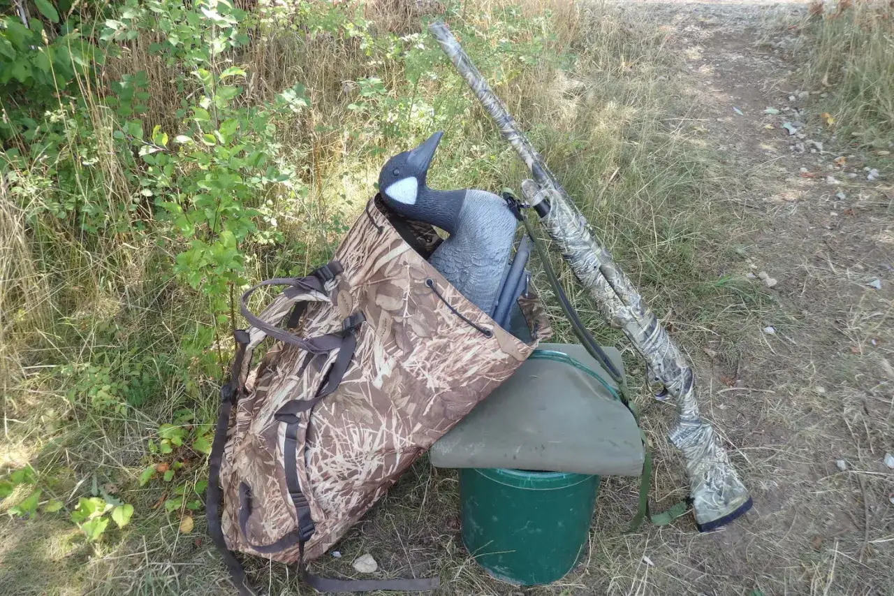 A camouflage backpack holds a goose decoy and a shotgun. Ready for the goose jagd.
