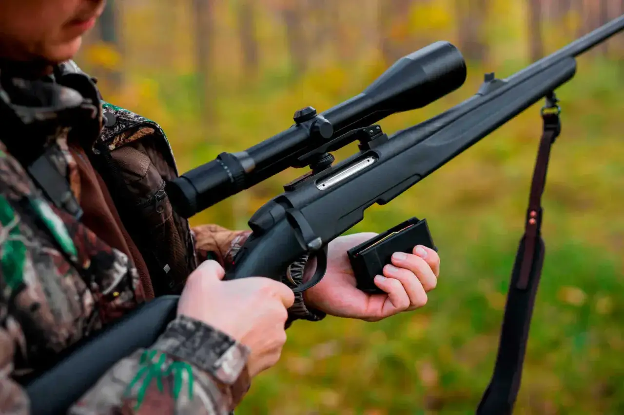 Jäger bereitet sich auf die UVV Jagd vor, lädt sein Gewehr mit Zielfernrohr und Magazin.