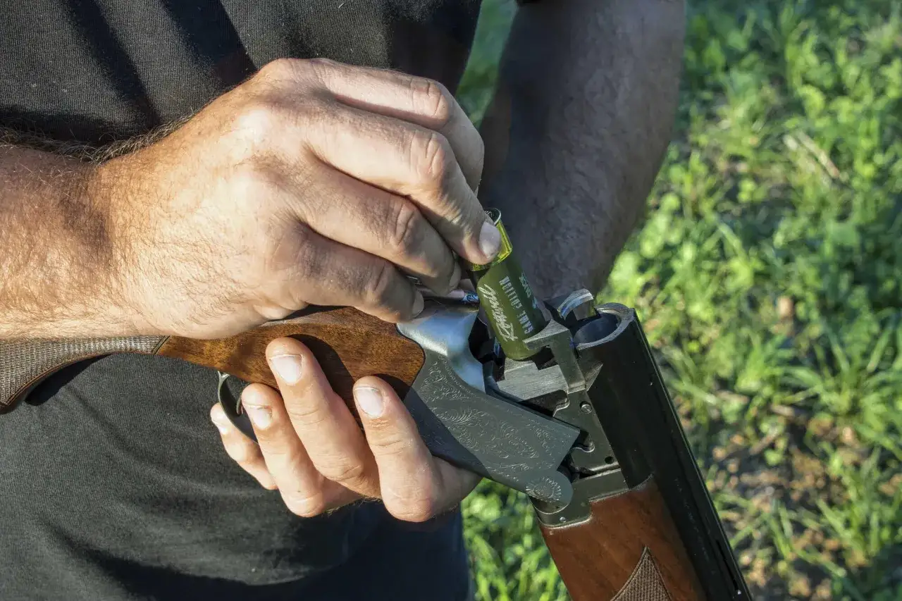 Mann lädt eine Flinte mit Stahlschrotbeschuss. Die Jagdsaison beginnt bald.
