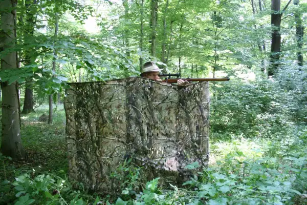 Jäger im Tarnzelt im Wald, bereit, richtig blatten.